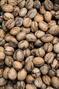 Top view of unshelled browned walnuts on the counter in market. natural food background of nuts