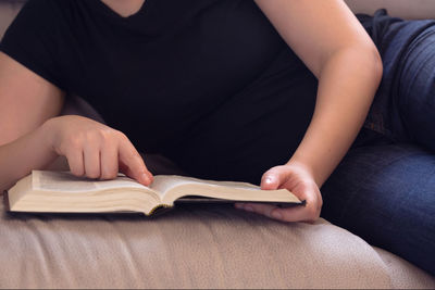 Midsection of person reading book