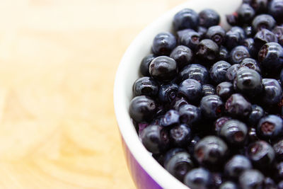 Blueberries in a rounded bowl on a wooden table