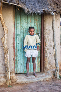 Boy smiling while standing by closed door