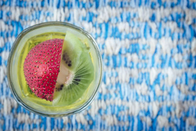 Directly above of kiwi and strawberry drink in glass on table