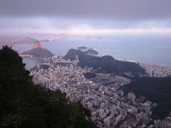 Aerial view of cityscape by sugarloaf mountain against cloudy sky