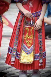 Midsection of woman standing in traditional clothing
