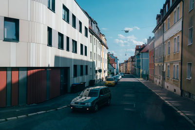 Cars on road amidst buildings in city