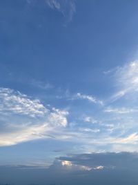 Low angle view of sunlight streaming through clouds