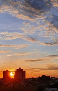 Silhouette buildings against sky during sunset