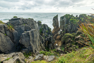 Panoramic shot of rocks on beach against sky