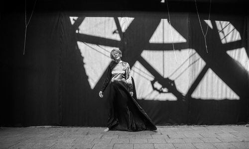 Low angle view of silhouette woman standing on street