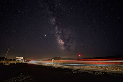 Light trails on road against sky at night