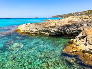 Scenic view of beach against clear blue sky