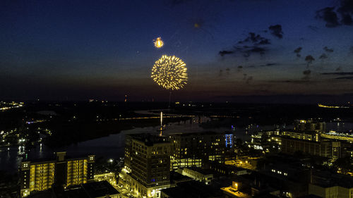 Aerial view of illuminated cityscape against sky at night