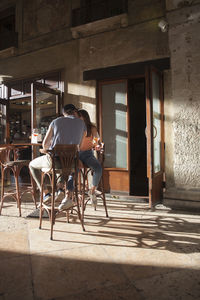 Rear view of people sitting on chair in building