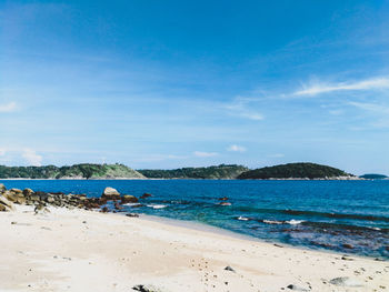 Scenic view of beach against blue sky