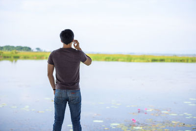 Rear view of man standing in water
