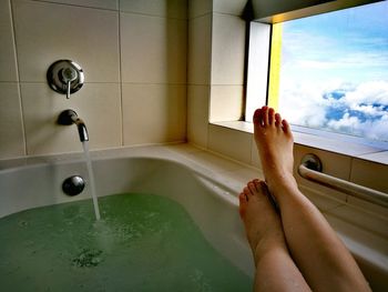 Low section of woman relaxing in bathroom