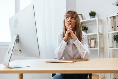 Portrait of young woman using mobile phone at home