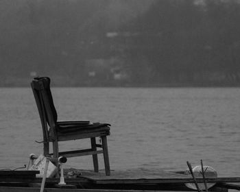 Empty seats on table by sea
