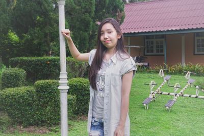 Portrait of woman smiling while standing in yard