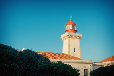 Low angle view of lighthouse against buildings