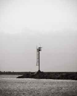 Wind turbines in sea against sky