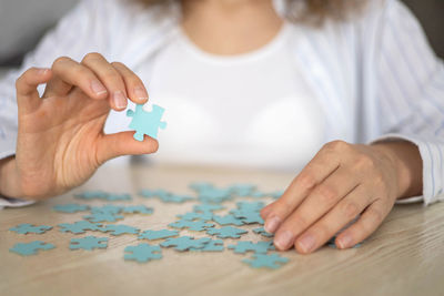 Midsection of woman playing jigsaw puzzle