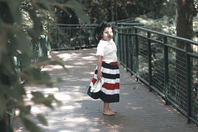 Full length portrait of girl walking on footbridge