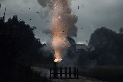 People with fire crackers against built structure