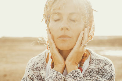 Woman with eyes closed standing outdoors