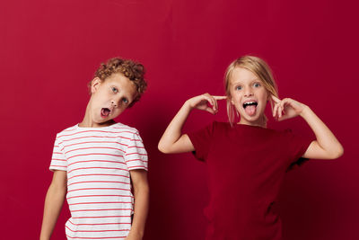 Cute sibling against red background