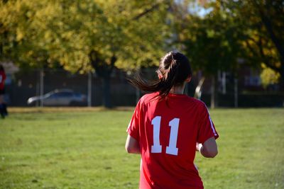 Rear view of a girl standing on field