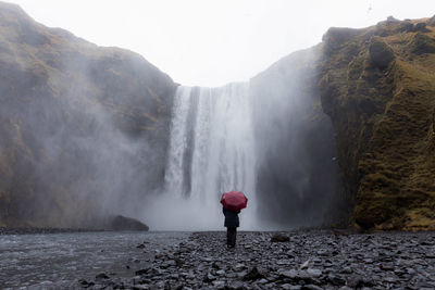 Rear view of woman looking at waterfall