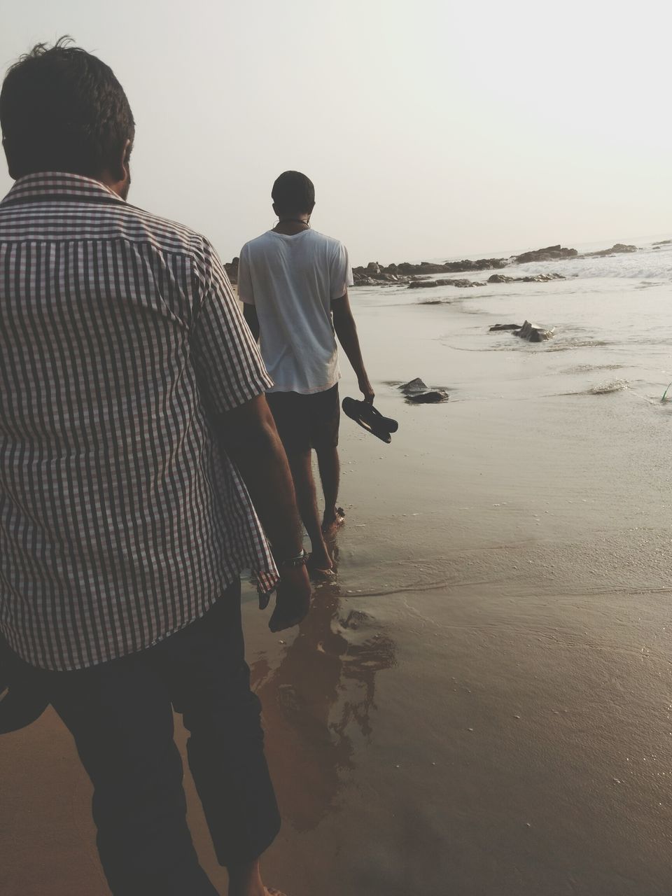 REAR VIEW OF MEN ON BEACH