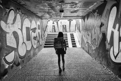 Rear view of student walking up an underground subway