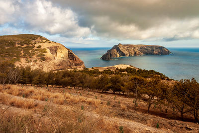 Scenic view of sea and mountains against sky