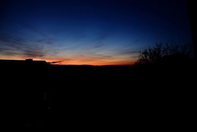 Silhouette landscape against sky at sunset