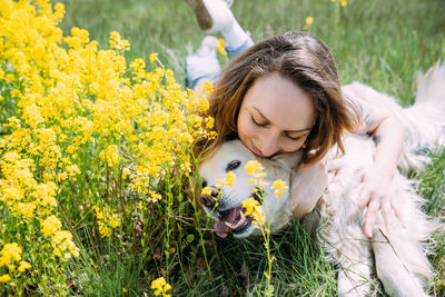 Young beautiful woman and her golden retriever dog having fun in summer