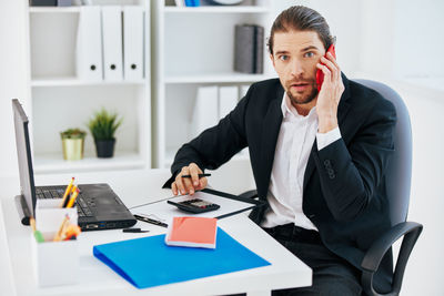 Man using mobile phone while sitting on table