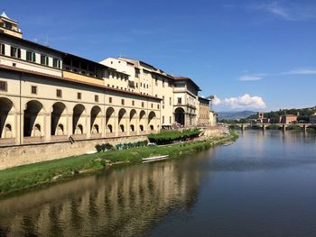 Arch bridge over river against buildings in city