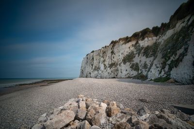 Surface level of rocks on shore against sky