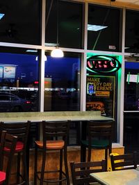 Empty chairs and tables in restaurant at night