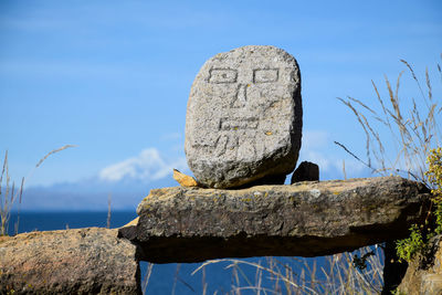 Close-up of rock by sea against sky