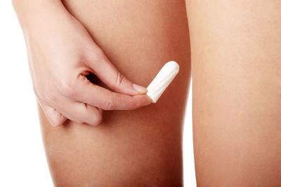 Close-up of woman holding hands over white background