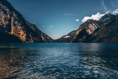 Scenic view of lake by mountains against sky