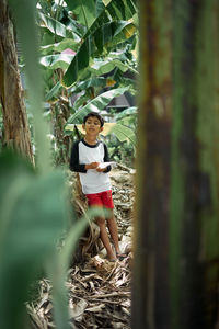 Portrait of woman standing by tree