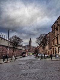 View of city street against cloudy sky