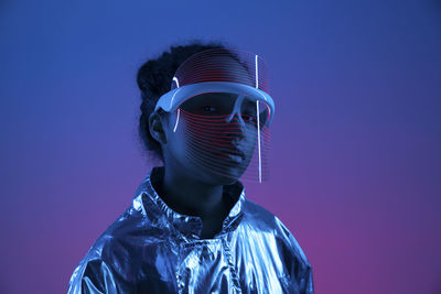Woman wearing futuristic smart glasses against multi-colored background