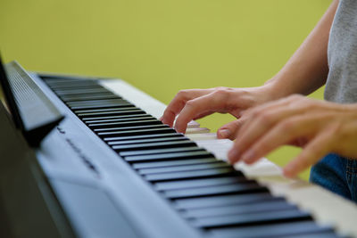 Hands of a girl playing the electronic piano. the girl plays the synthesizer.