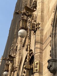 Low angle view of statue amidst buildings against sky