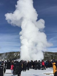 People looking at old faithful geyser