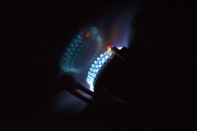 Close-up of lit candle in darkroom